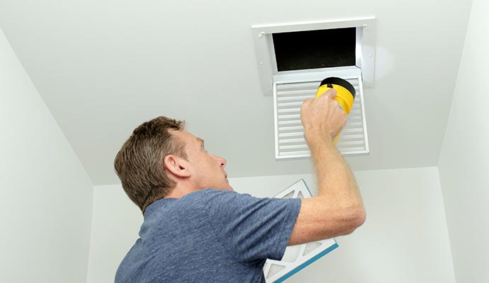 Professional inspecting a duct system