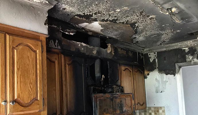 fire damaged kitchen with charred ceiling