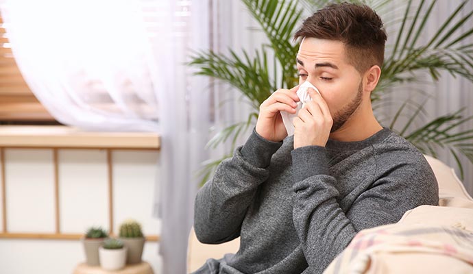 Person sneezing due to mold exposure