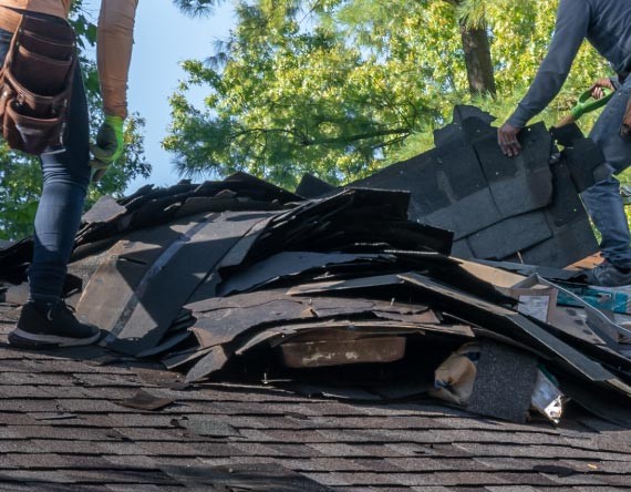 Professional workers restoring a damaged roof