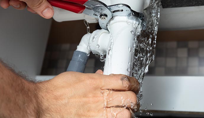 Person restoring broken water pipe